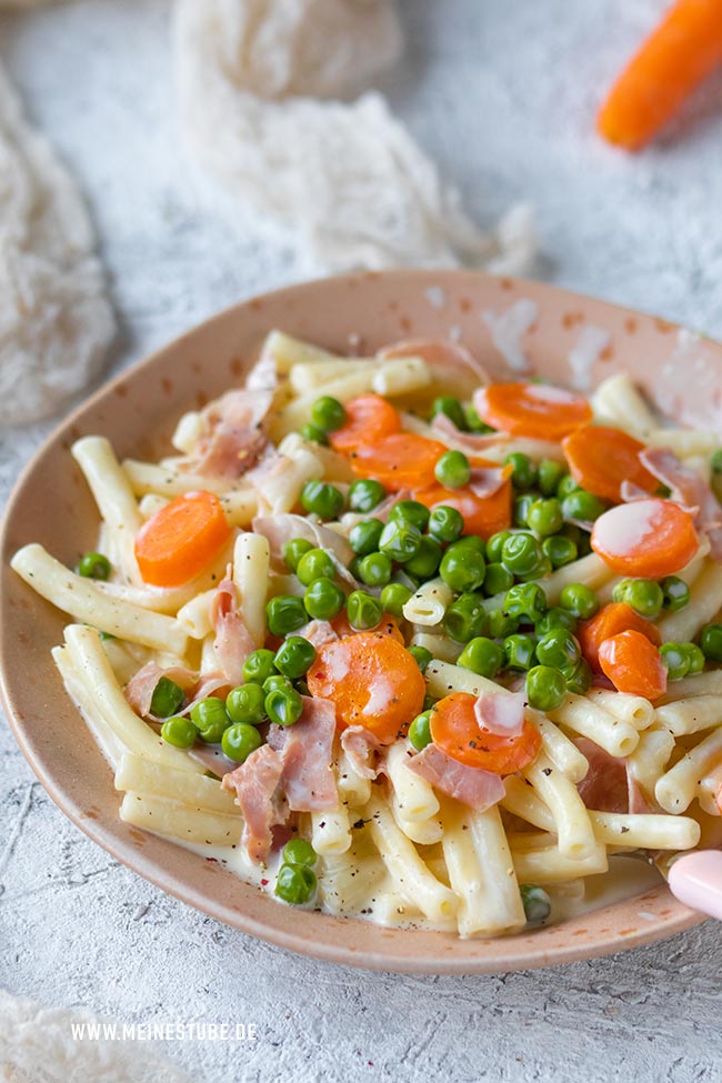 Nudeln in Schinken-Sahnesoße mit Käse, Erbsen und Möhren